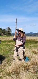 Carrie Garrison-Laney stands with an earth corer in the field