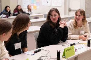 Students participating in Orca Bowl discuss their answer during the buzzer round