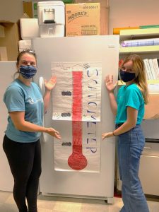 Scientists pointing to a drawn red thermometer, indicating lots of scat!