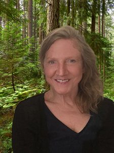 Robyn Ricks backed by a lush green forest