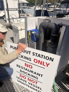Aaron Barnett examines the inside of the pumpout station at Boat Street Marina.