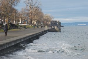 High water laps at a paved walkway on Alki Beach in West Seattle