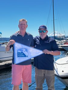 Dwight Jones (left), CEO, and Andrew Shroyer, general manager, of Lakewood and Leschi marinas hold up the Clean Marina flag