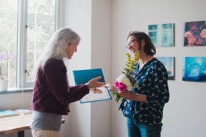 Former Dean of UW College of the Environment Maya Tolstoy presents WSG interim director Kate Litle with a certificate of nomination for the Governor's Outstanding Leadership Award.