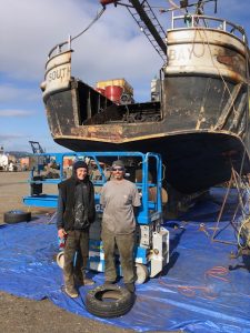 Rob Seitz (right) and his son stand in front of their family boat, the South Bay.