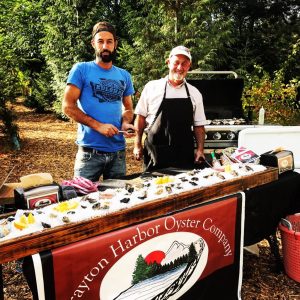 Steve Seymour (right) with his son, Mark Seymour (left), serving up some fresh oysters.