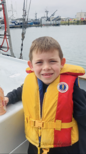 Amy Sharp's son wearing a life vest on a boat