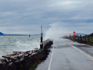 A wave overtopping road barriers on Lummi Island