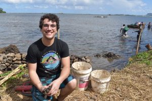 Octavio Cruz smiling and sitting by the water