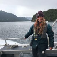 Olivia Horwedel on a boat with a fjord in the background