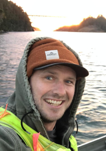 Stuart Thomas on a kayak with water behind him