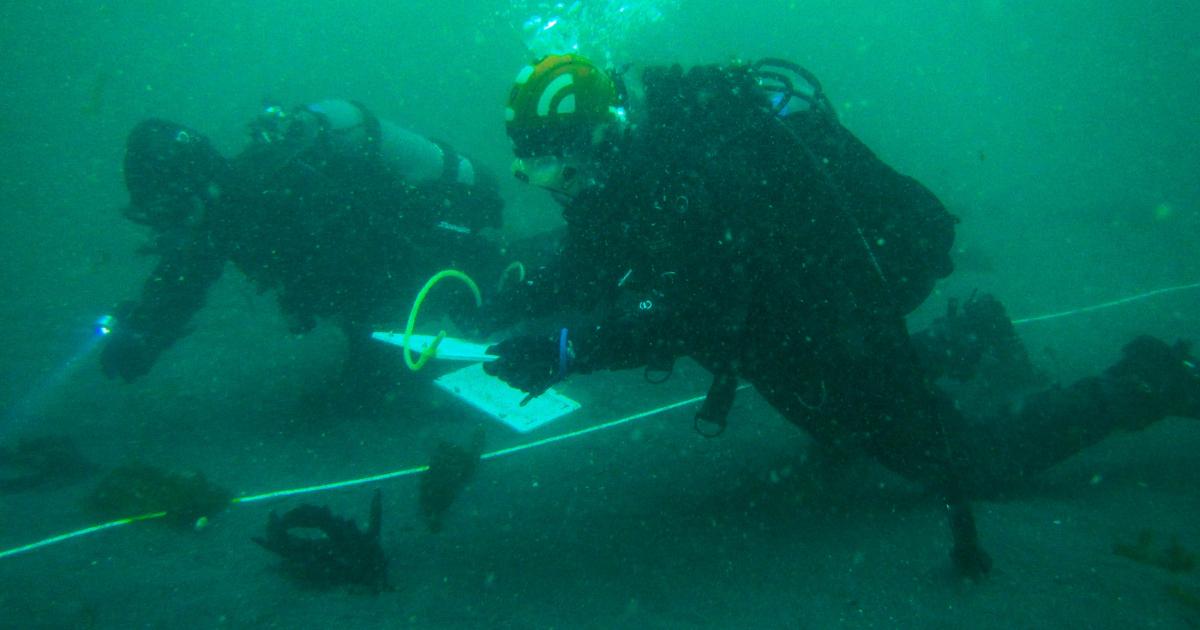 Two divers in the Elwha River conducting dam removal restoration monitoring
