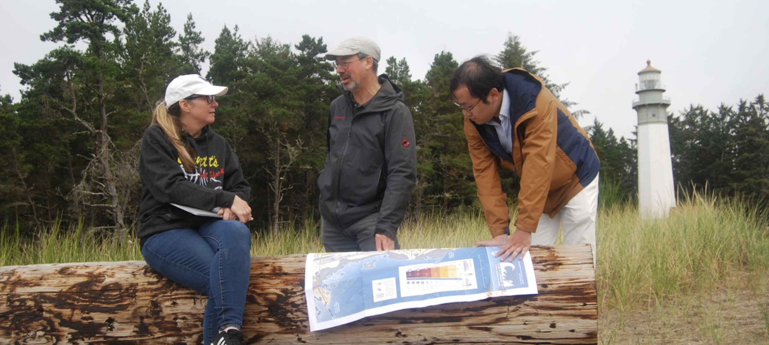 Washington Sea Grant Coastal Hazards Specialist Carrie Garrison-Laney sits with emergency managers and educators on the shore