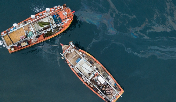 Oil in the water alongside two boats