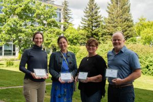 WSG Fisheries team, including Jenna Keeton, Bridget Trosin, Brandii O'Reagan, and Robert Maw, smile while holding awards.