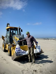 A volunteer places marine debris into the bucket of an excavator