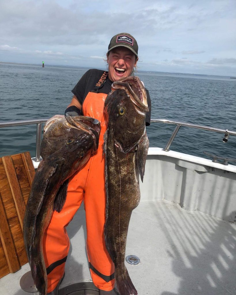Marina holds a large lingcod in each hand