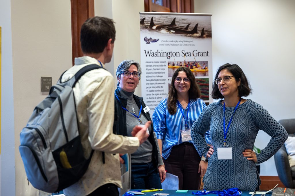 Three WSG staff greet someone at the annual Shellfish Growers Conference